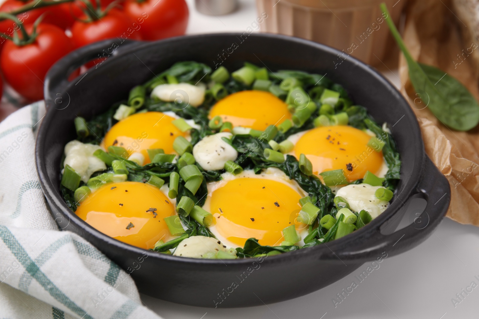 Photo of Tasty green Shakshouka served on white table, closeup