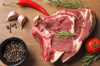 Flat lay composition with fresh meat on wooden table