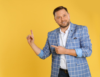 Photo of Portrait of happy mature man on yellow background, space for text