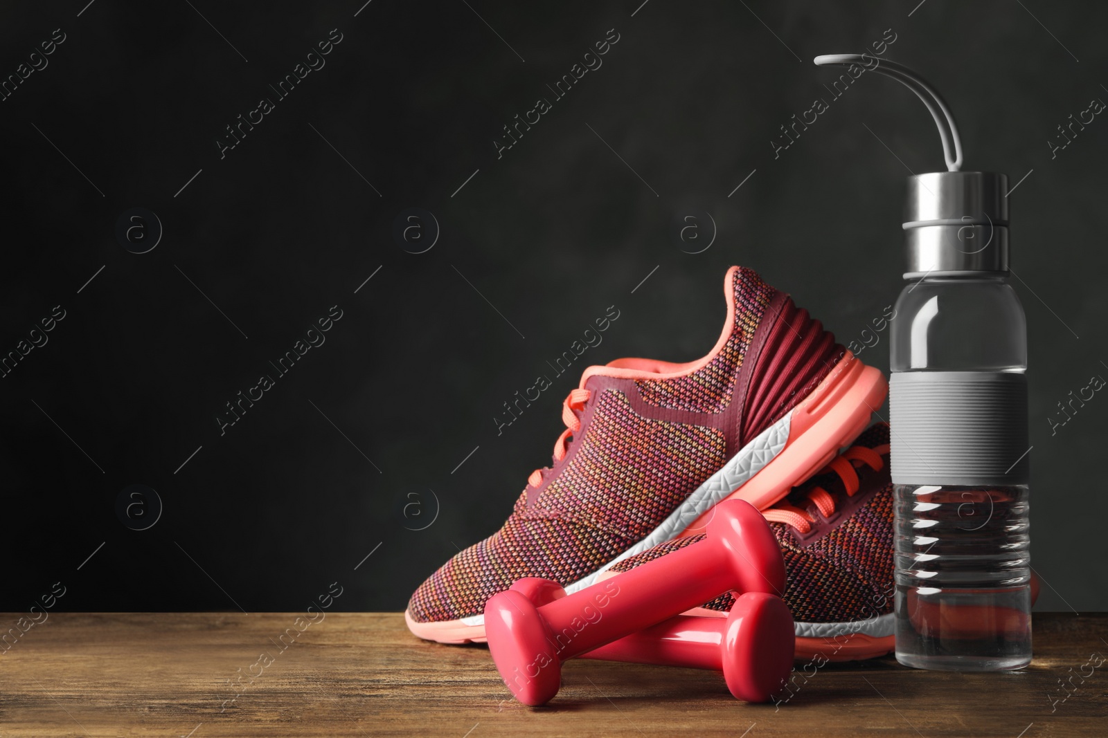 Gym equipment and accessories on floor against dark background. Space for text Photo of Gym equipment and accessories on floor against dark background. Space for text