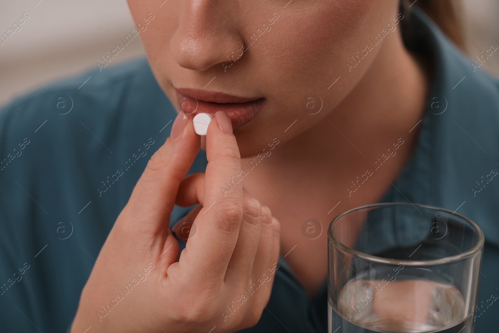 Photo of Woman with glass of water taking antidepressant pill, closeup
