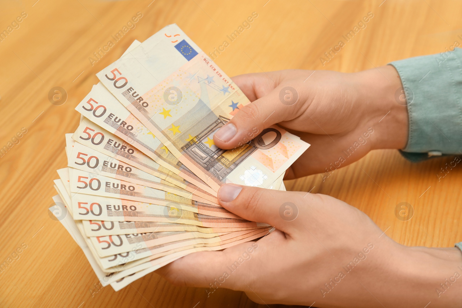 Photo of Man with Euro banknotes at table, closeup