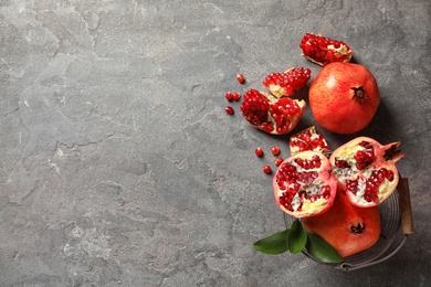 Flat lay composition with ripe pomegranates and space for text on grey background