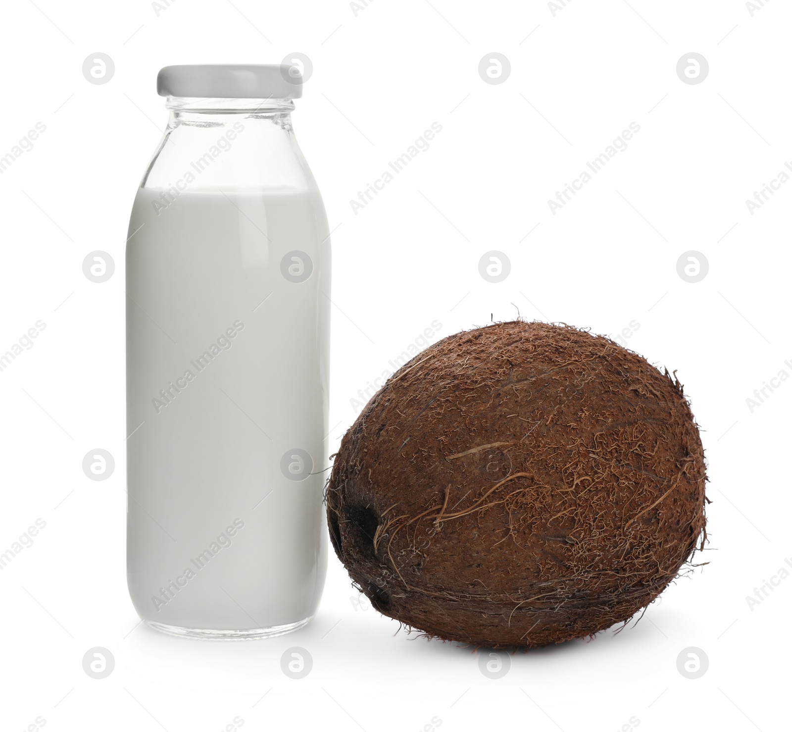 Photo of Bottle of coconut milk and nut on white background