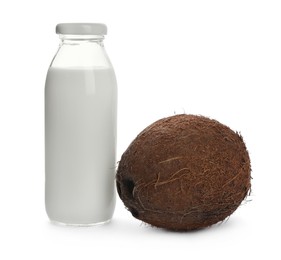 Photo of Bottle of coconut milk and nut on white background
