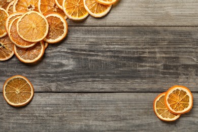 Dry orange slices on wooden table, flat lay. Space for text