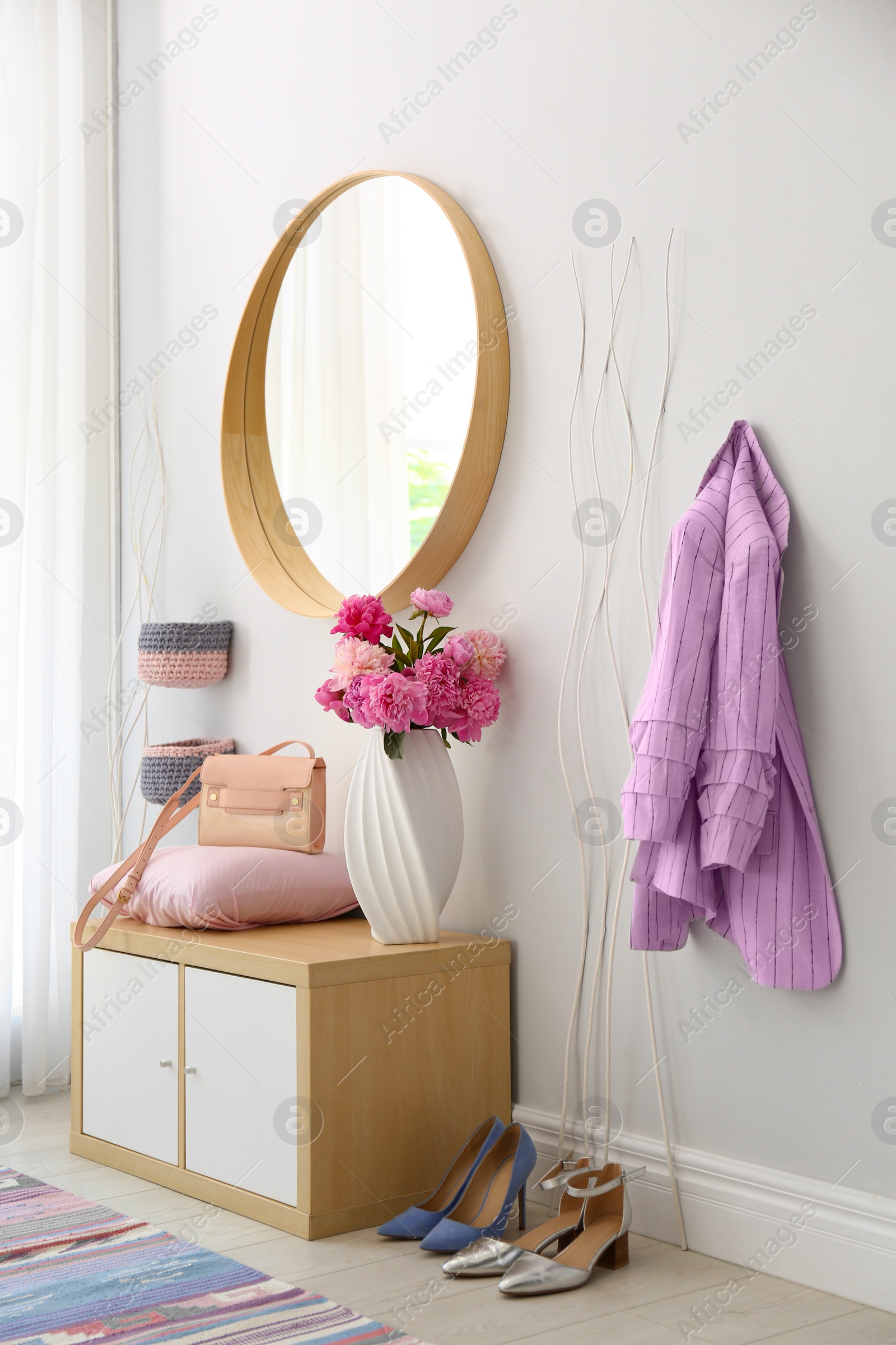 Photo of Stylish hallway interior with round mirror on white wall