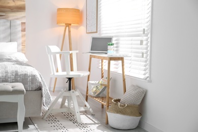 Comfortable workplace with laptop near window at home