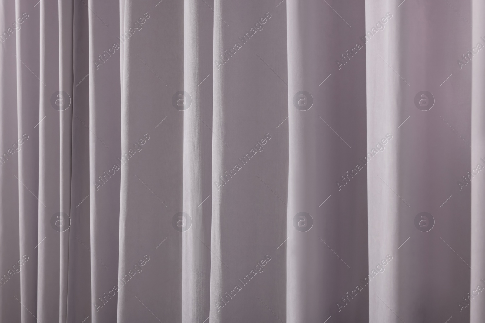 Photo of Beautiful light grey window curtains as background, closeup