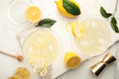Photo of Delicious bee's knees cocktails and ingredients on white table, flat lay