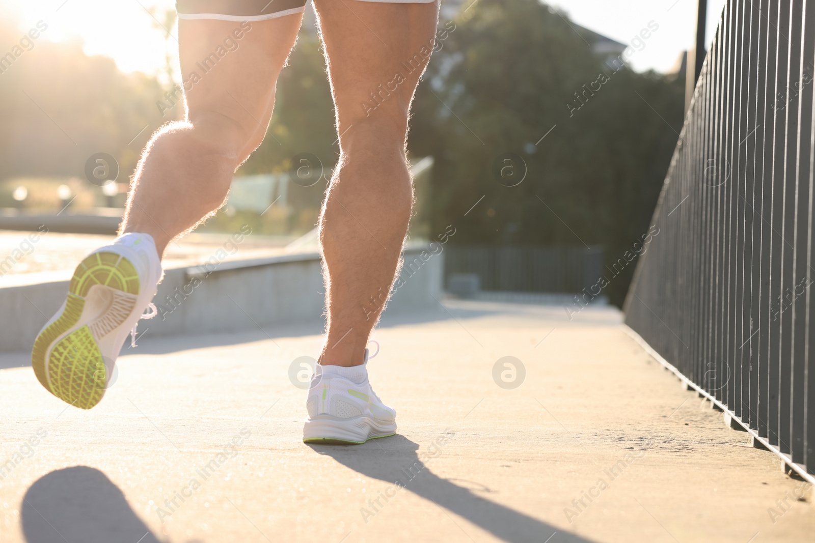 Photo of Man running outdoors on sunny day, closeup. Space for text