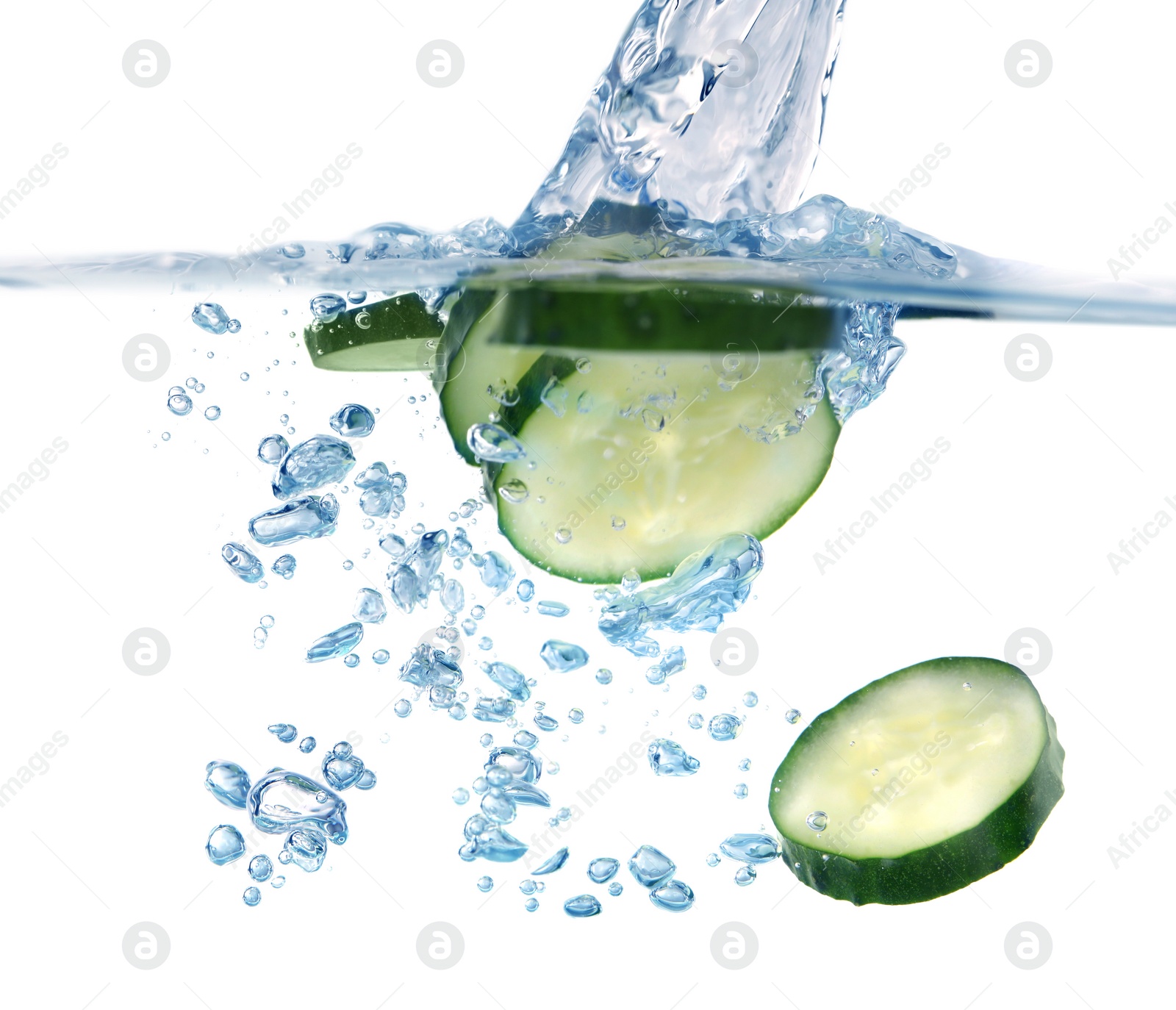 Photo of Slices of fresh cucumber falling into water on white background, closeup