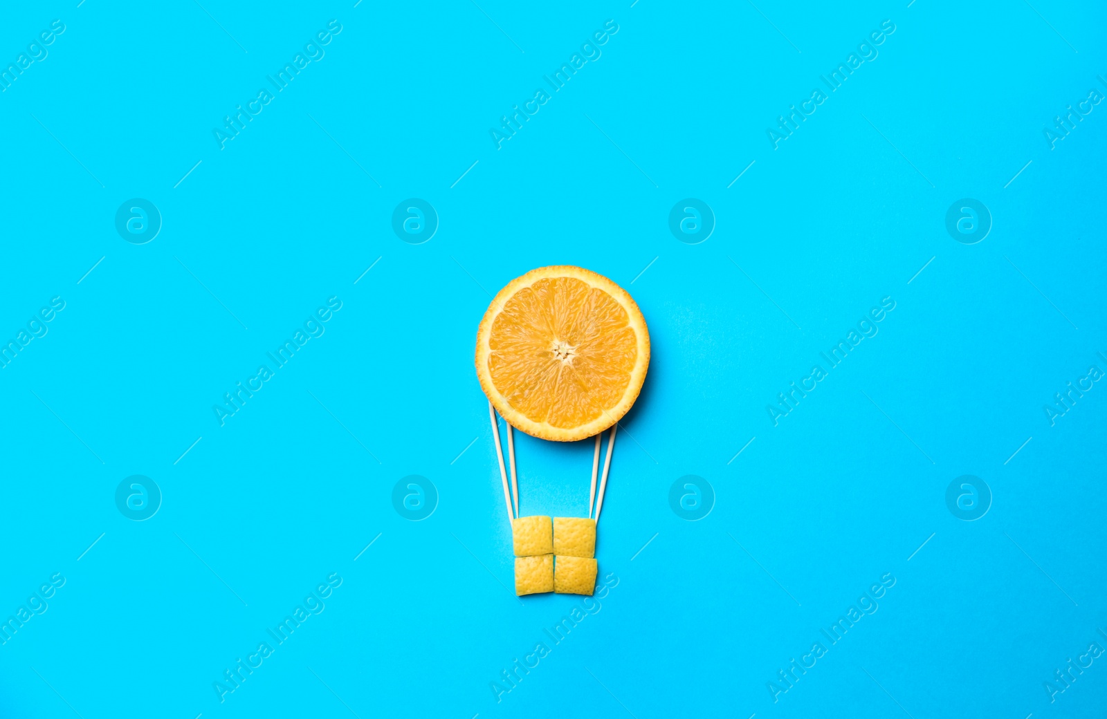 Photo of Hot air balloon made of orange on blue background, flat lay
