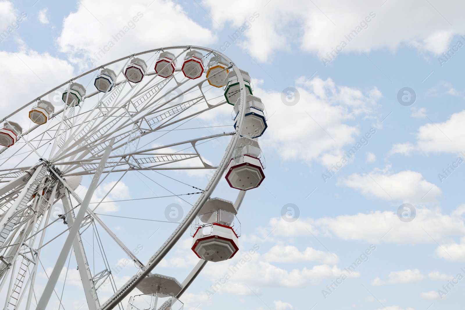 Photo of Large white observation wheel against sky, low angle view. Space for text