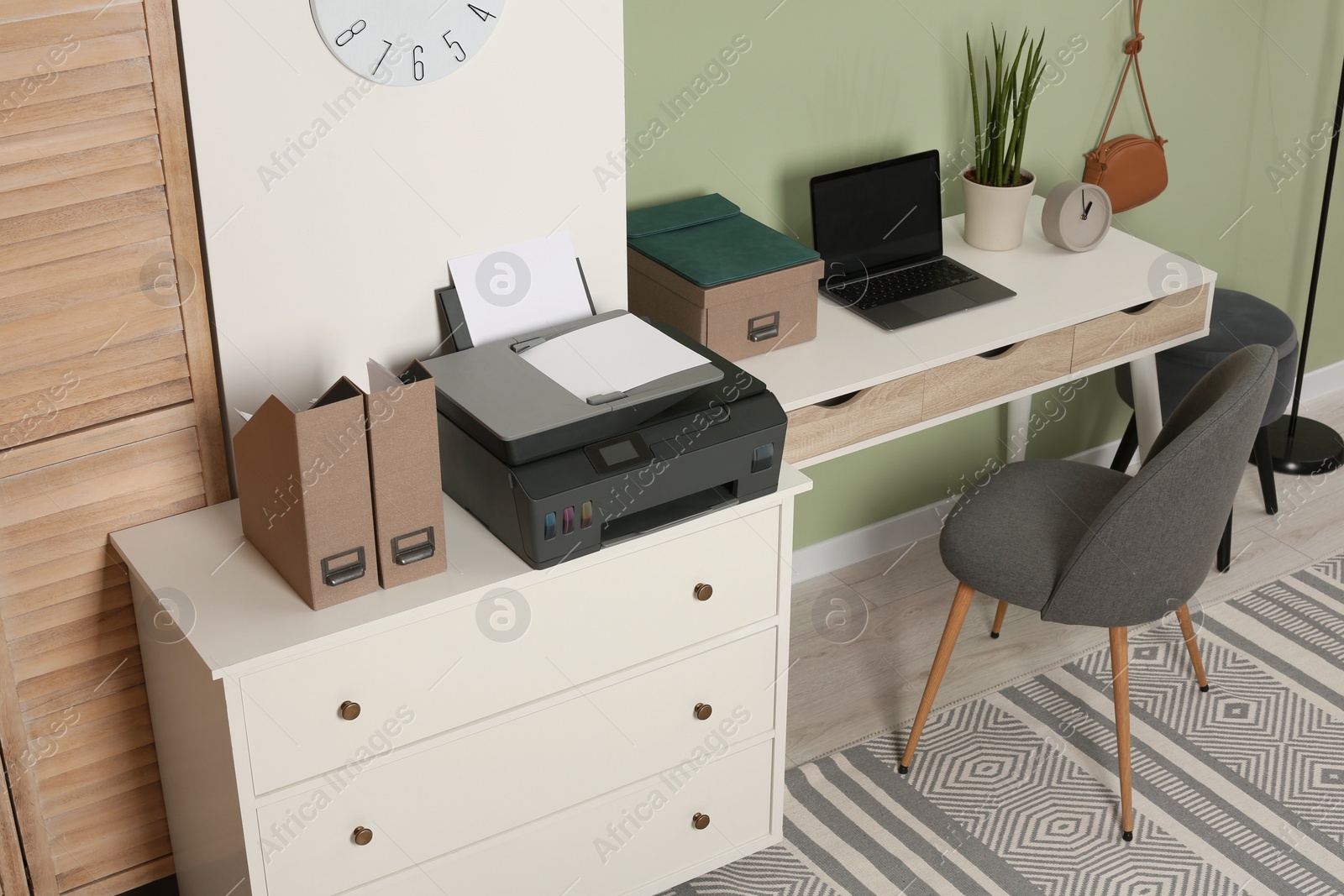 Photo of Stylish workplace with laptop and modern printer indoors