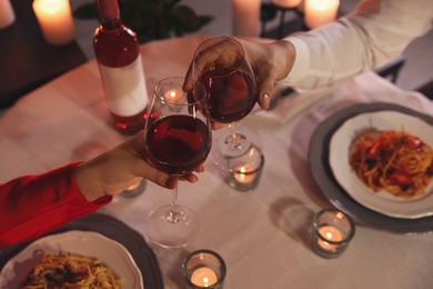 Photo of Couple clinking glasses of wine, above view. Romantic dinner