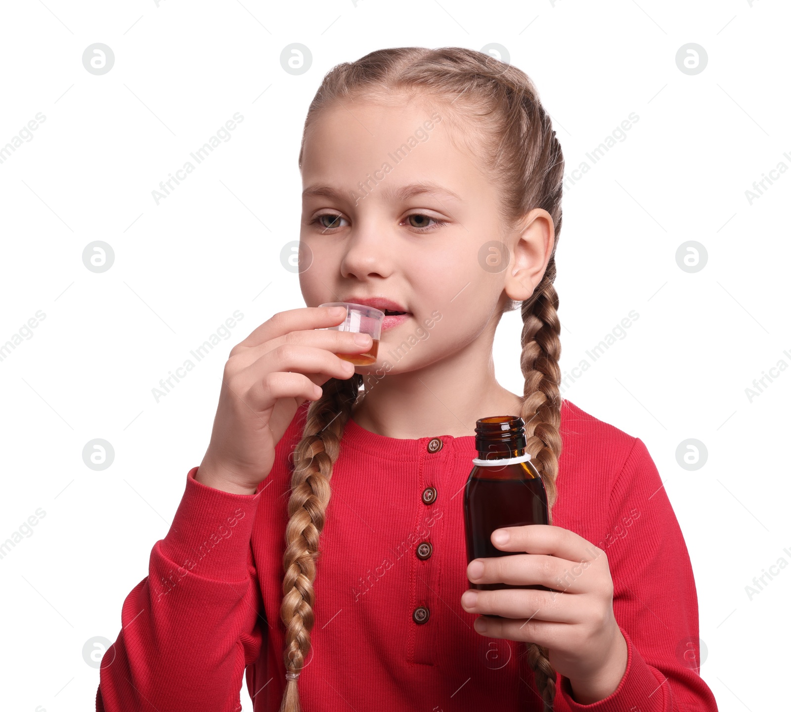 Photo of Cute girl taking syrup from measuring cup on white background