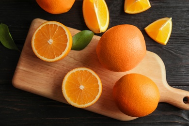 Photo of Fresh juicy oranges on wooden table, top view