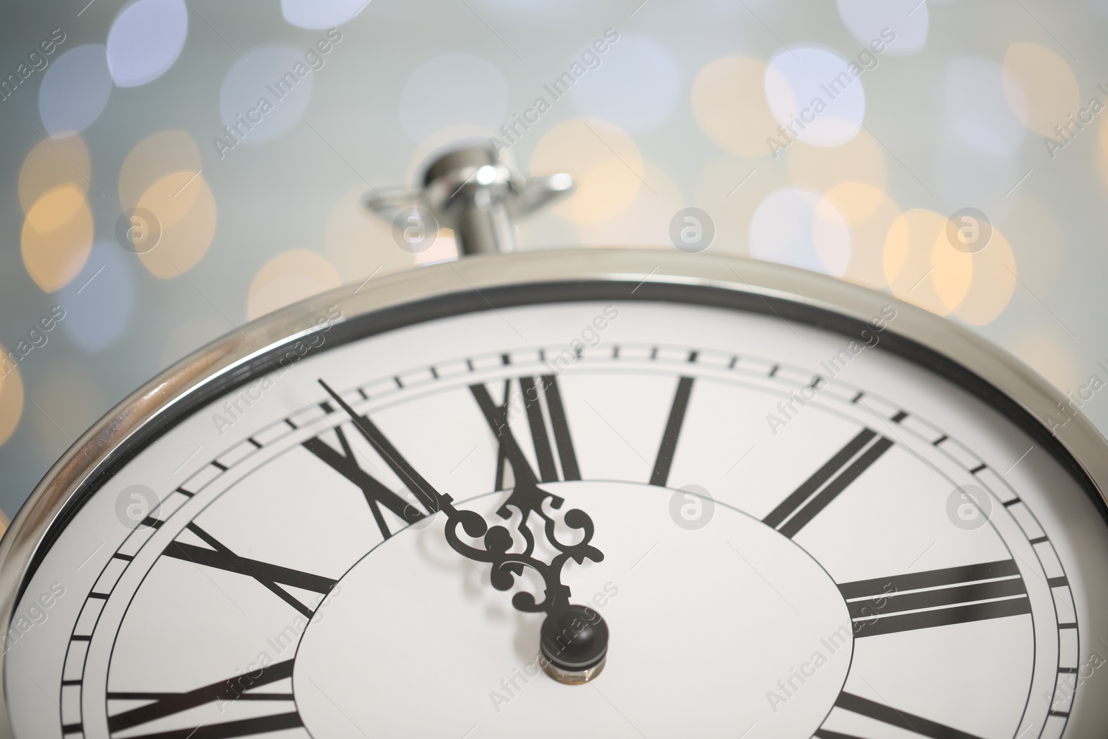 Photo of Clock showing five minutes until midnight on blurred background, closeup. New Year countdown