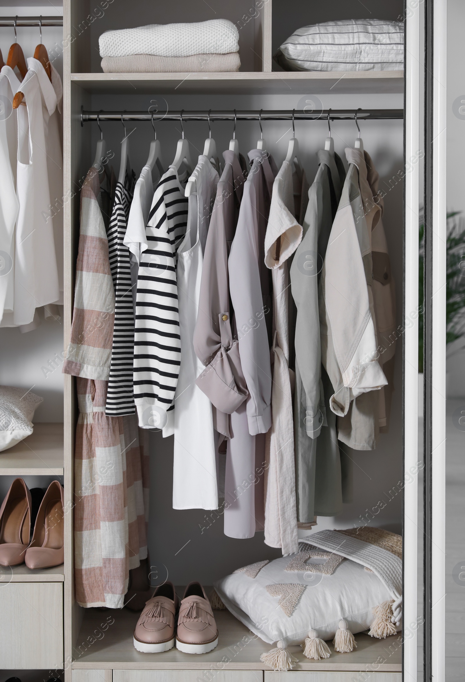 Photo of Wardrobe closet with different stylish clothes, shoes and home stuff in room