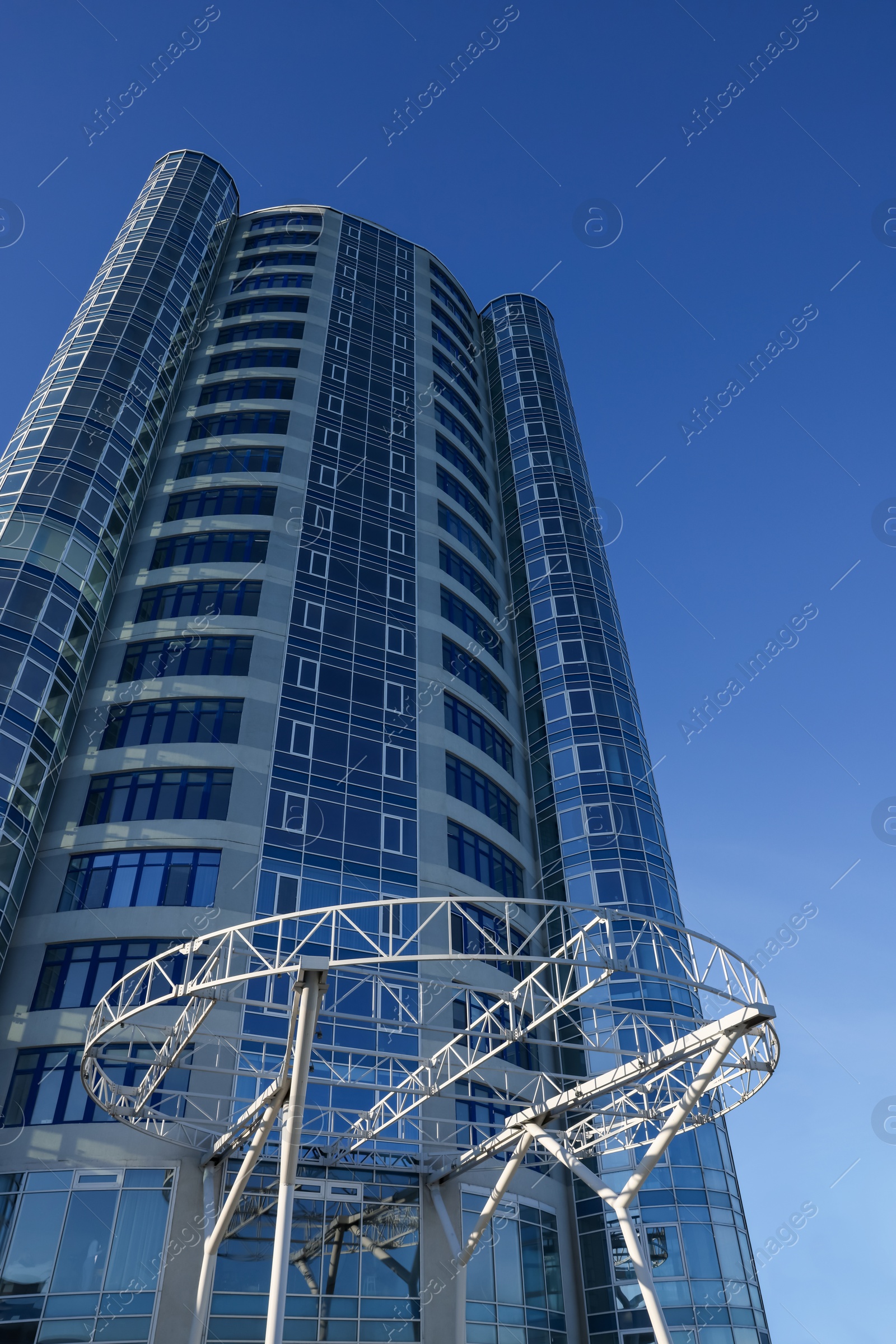 Photo of Beautiful skyscraper against blue sky on sunny day, low angle view