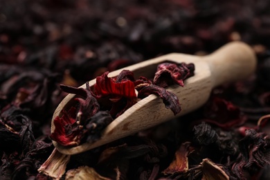 Photo of Wooden scoop with dry hibiscus tea, closeup