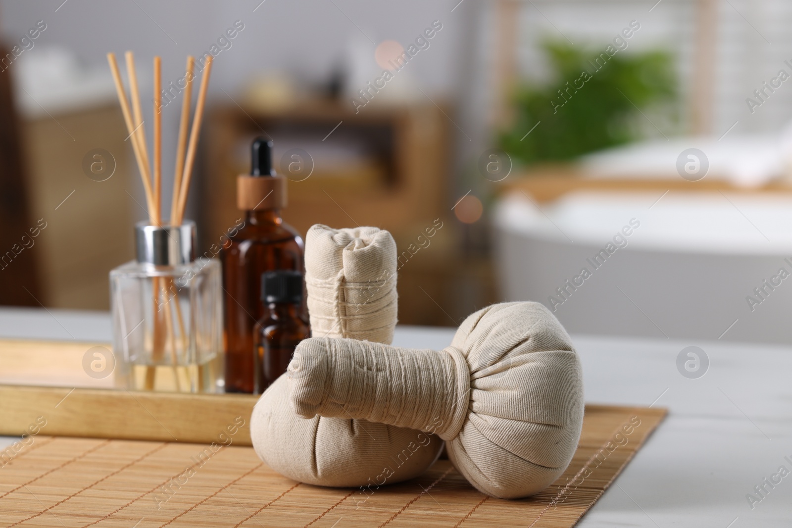 Photo of Spa composition with herbal bags on white table indoors, selective focus