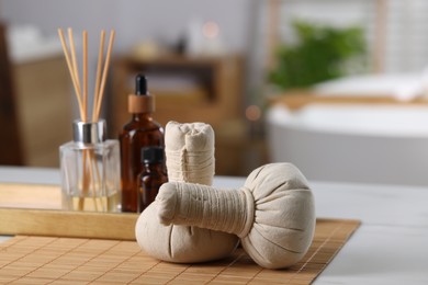 Photo of Spa composition with herbal bags on white table indoors, selective focus