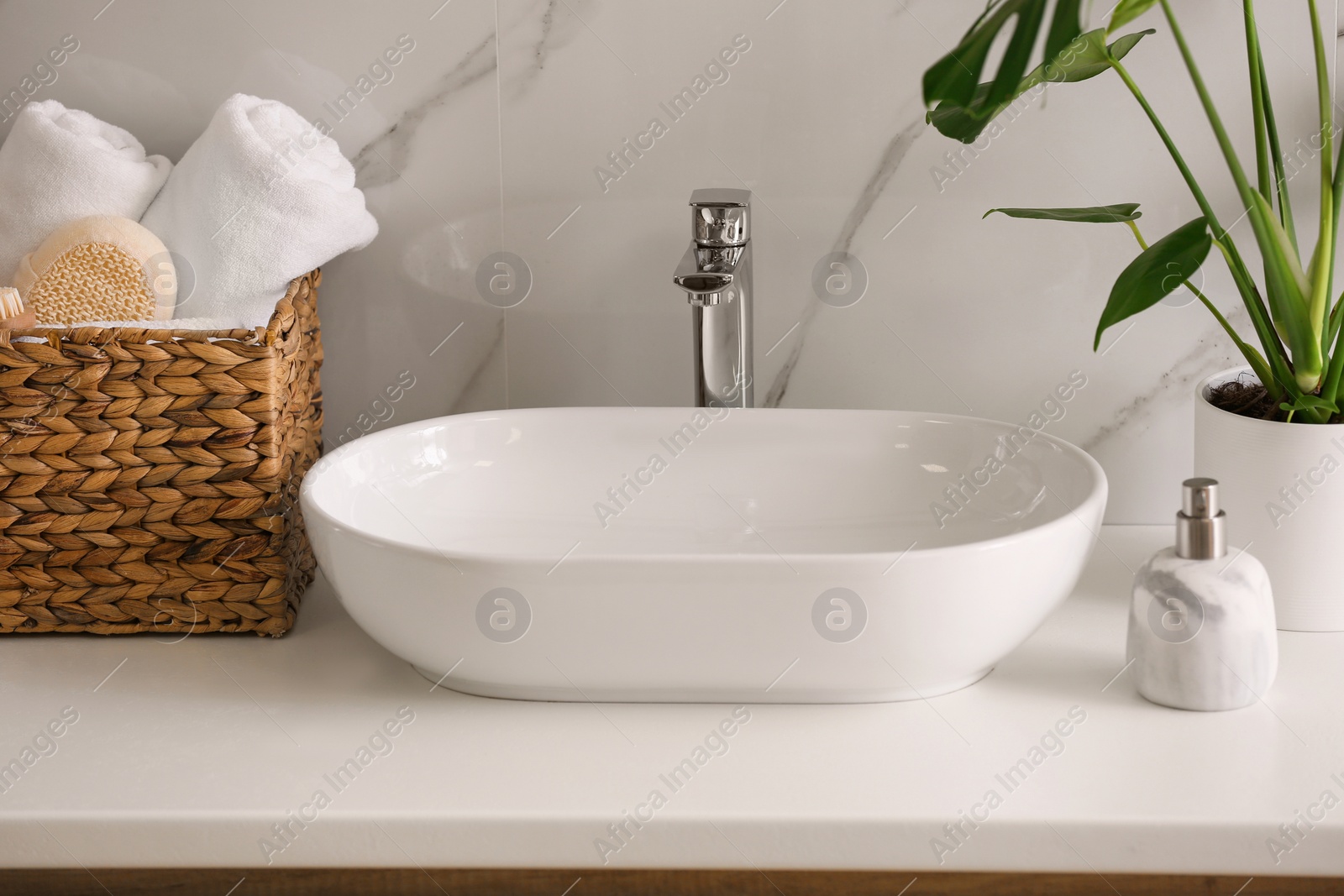 Photo of Stylish vessel sink on light countertop in modern bathroom