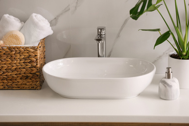 Photo of Stylish vessel sink on light countertop in modern bathroom