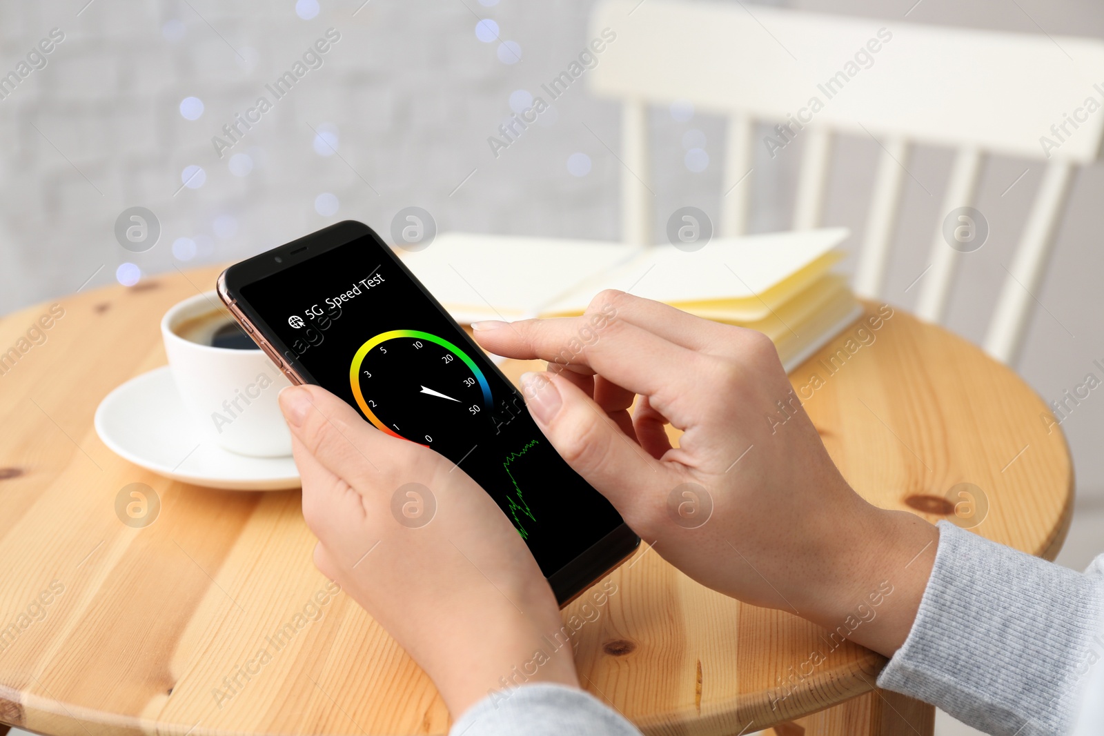 Image of 5G speed test. Woman using mobile phone at table, closeup