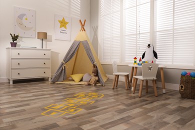 Photo of Yellow hopscotch floor sticker in room at home