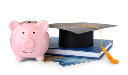 Photo of Graduation hat, credit cards and piggy bank isolated on white