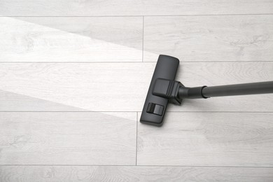 Image of Vacuuming dirty white wooden floor. Clean area after using device, top view