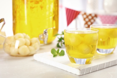 Glasses with tasty melon ball drink on light table