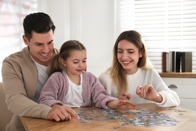 Happy family playing with puzzles at home