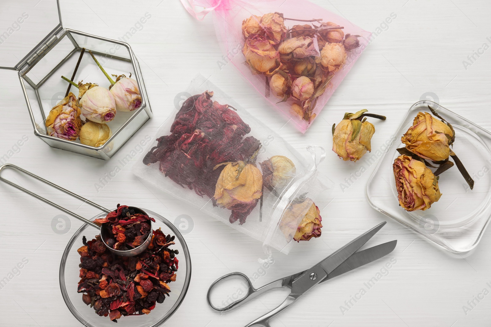 Photo of Scented sachet with dried flowers and scissors on white table, flat lay