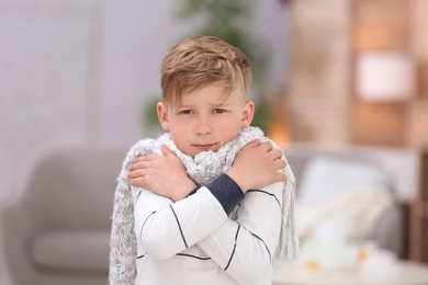 Photo of Sad little boy suffering from cold on blurred background