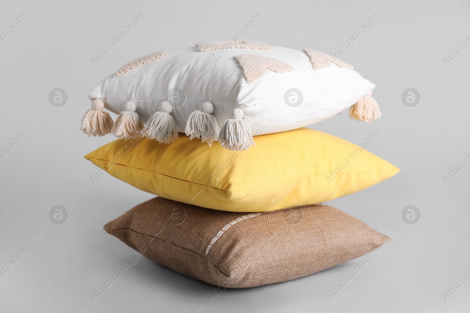 Photo of Stack of stylish soft pillows on grey background