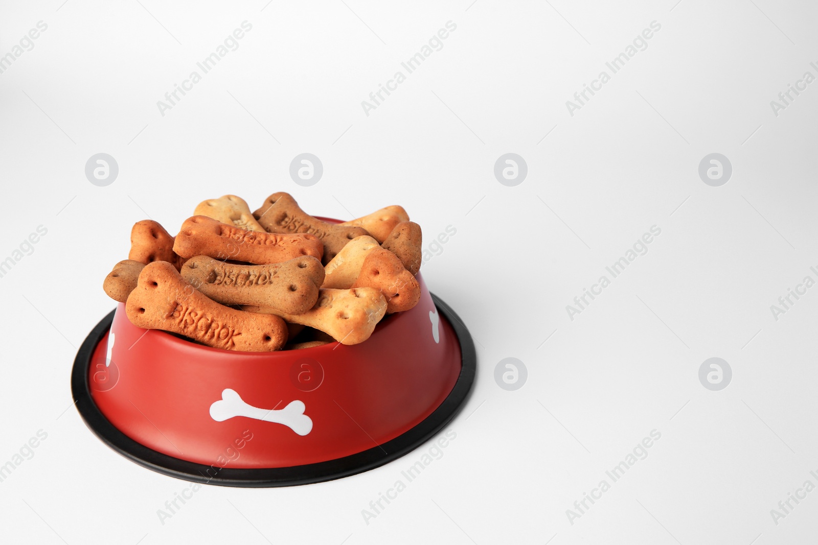 Photo of Bone shaped dog cookies in feeding bowl on white background, space for text