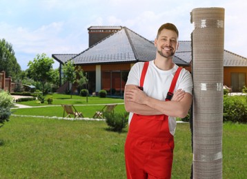 Image of Worker with rolled carpet outdoors on sunny day