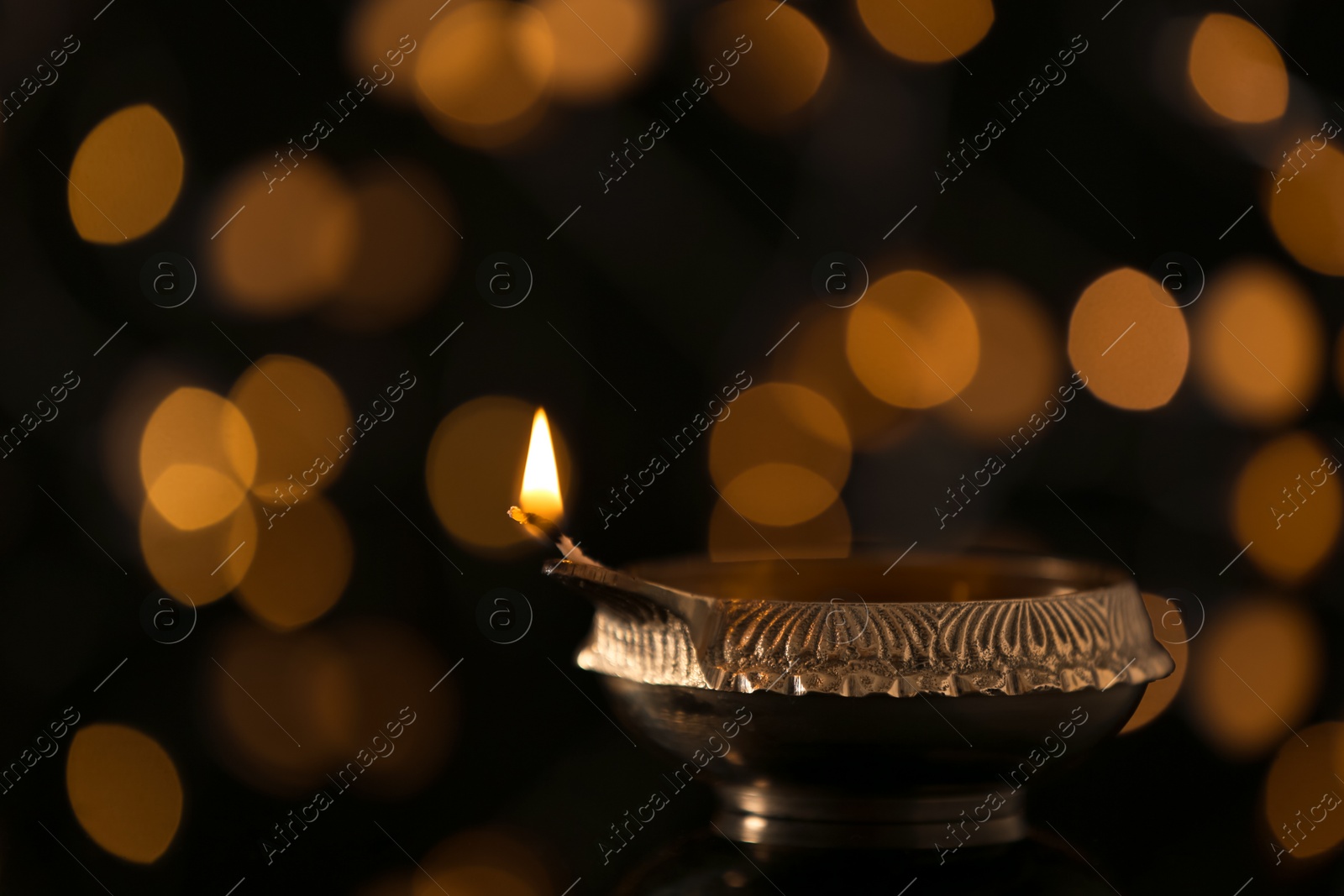 Photo of Diwali diya or clay lamp against blurred lights