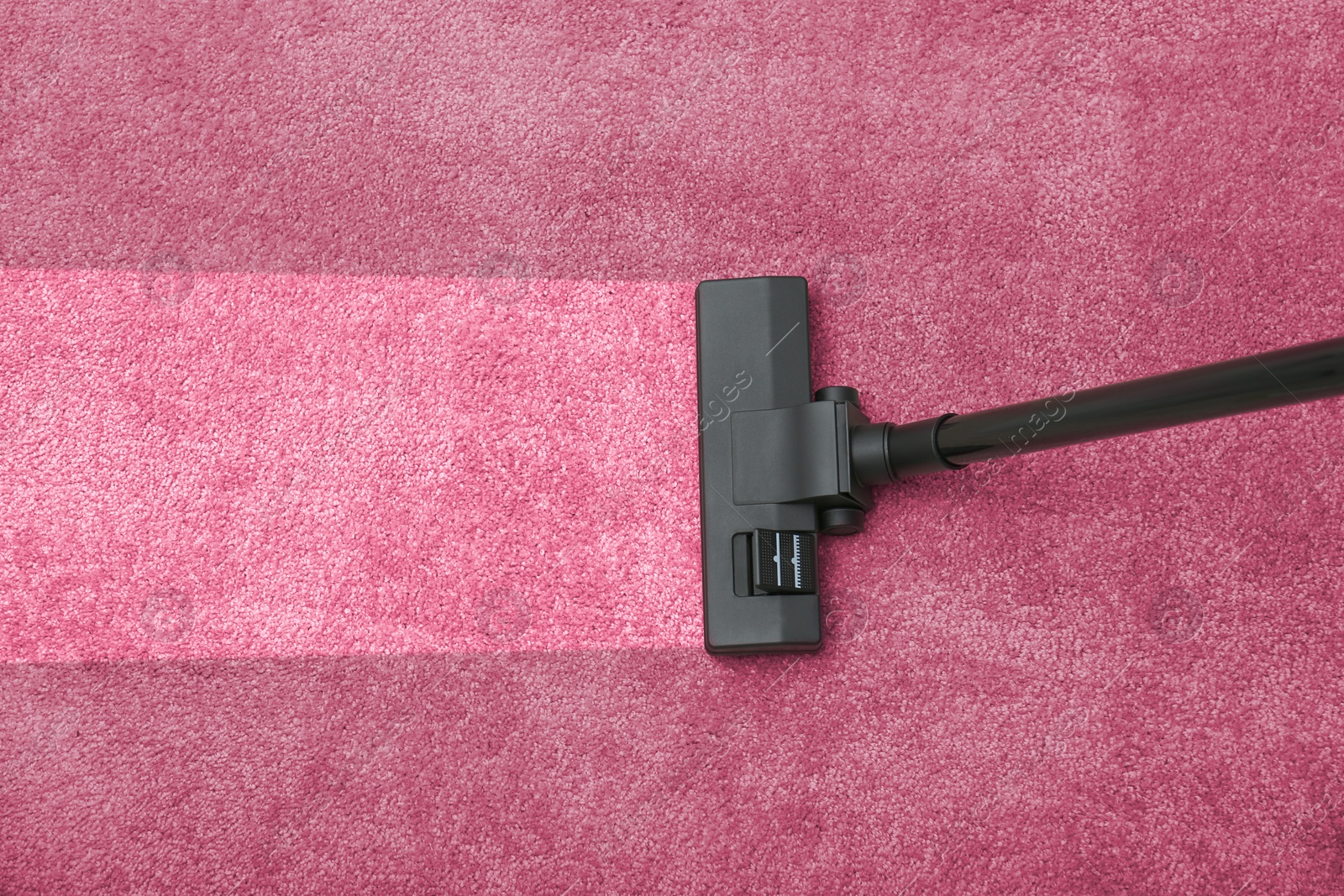 Image of Vacuuming dirty pink carpet. Clean area after using device, top view