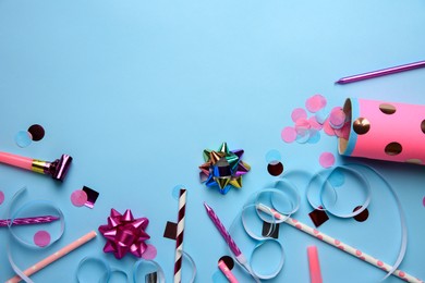 Photo of Party popper with confetti, blower and festive decor on light blue background, flat lay. Space for text