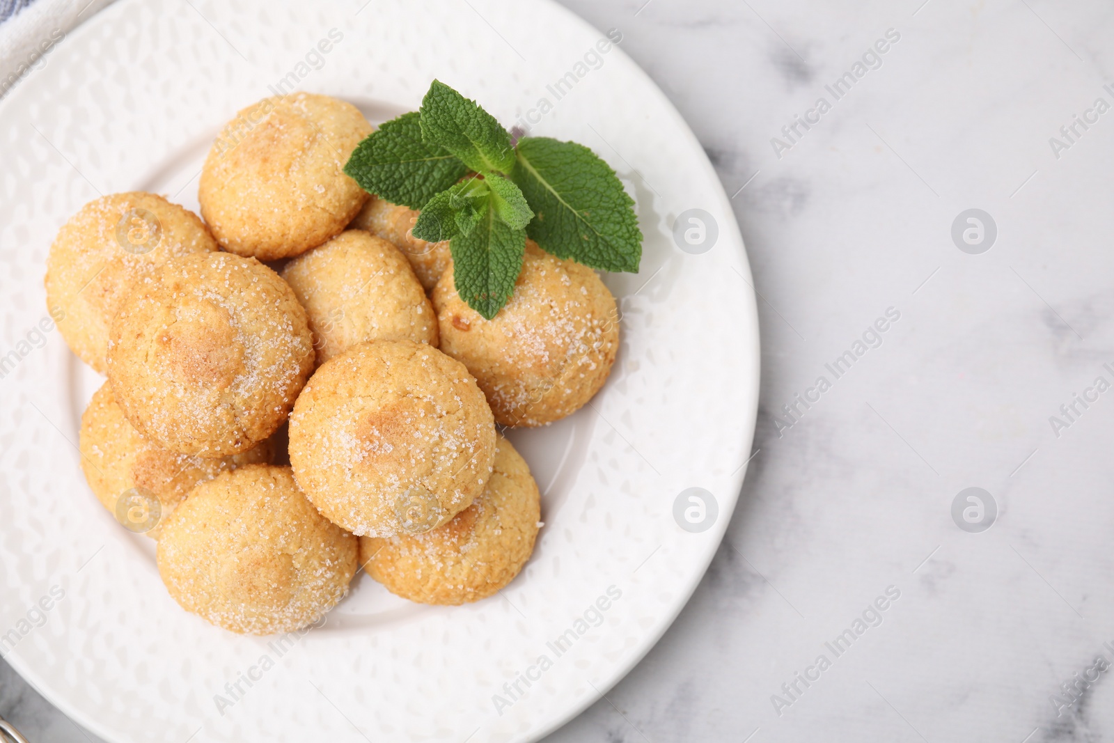 Photo of Tasty sweet sugar cookies and mint on white marble table, top view. Space for text