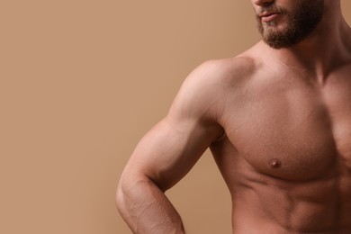 Photo of Muscular man on beige background, closeup and space for text. Sexy body