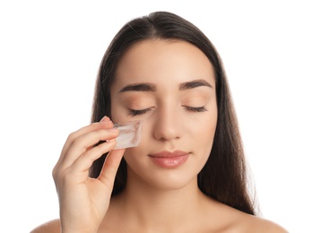 Young woman with ice cube on white background. Skin care