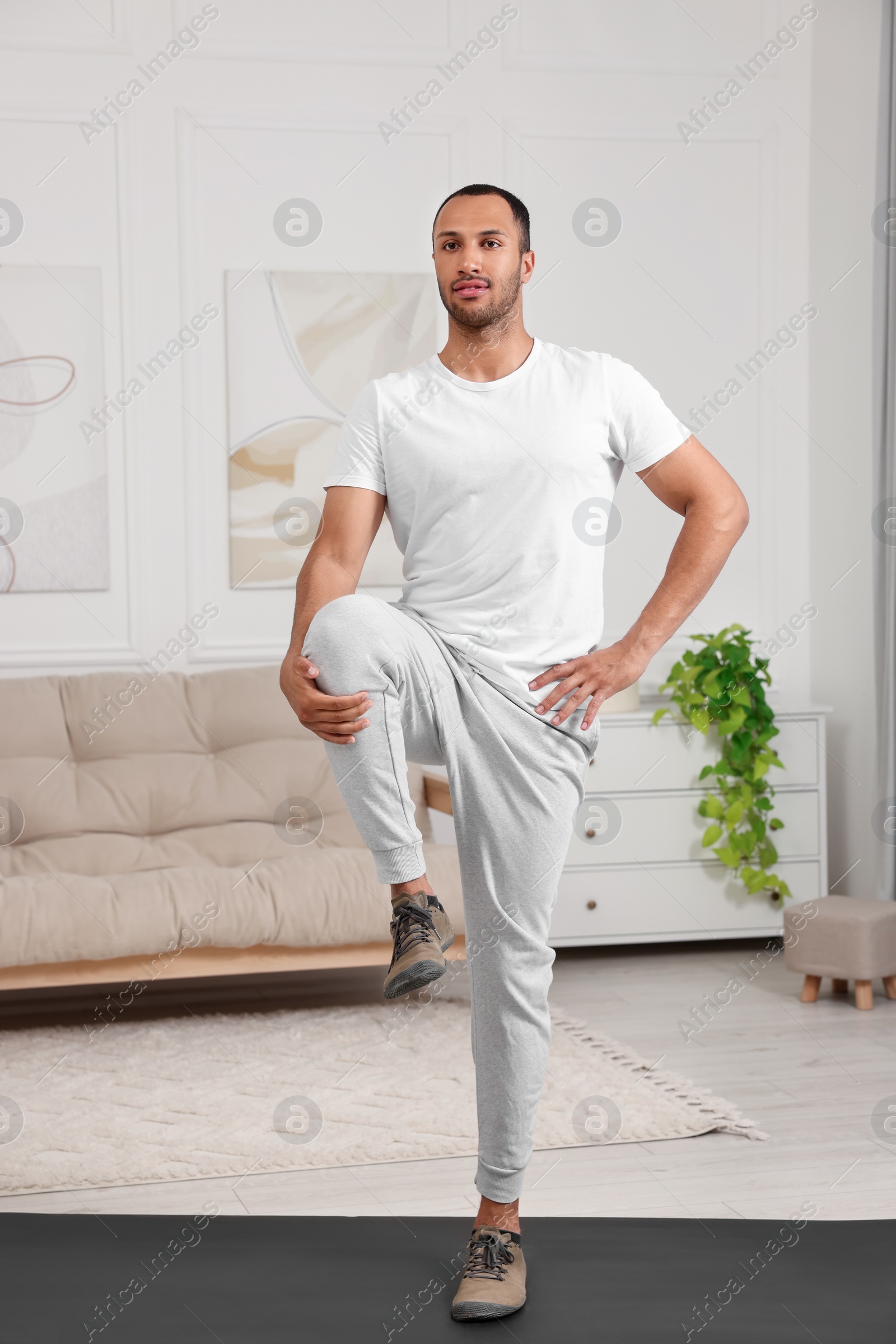 Photo of Man doing morning exercise on fitness mat at home