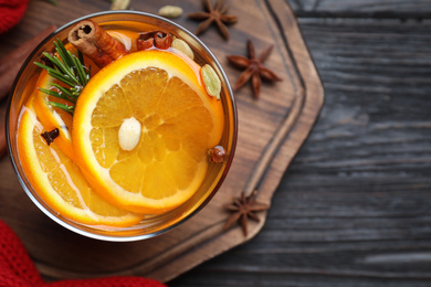 Photo of Aromatic mulled wine on black wooden table, top view