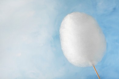 Photo of One sweet cotton candy on light blue background, space for text